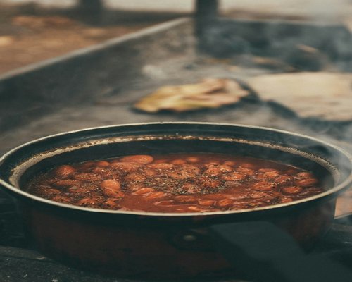 A pot of traditional Mexican beans simmering and fresh corn tortillas
